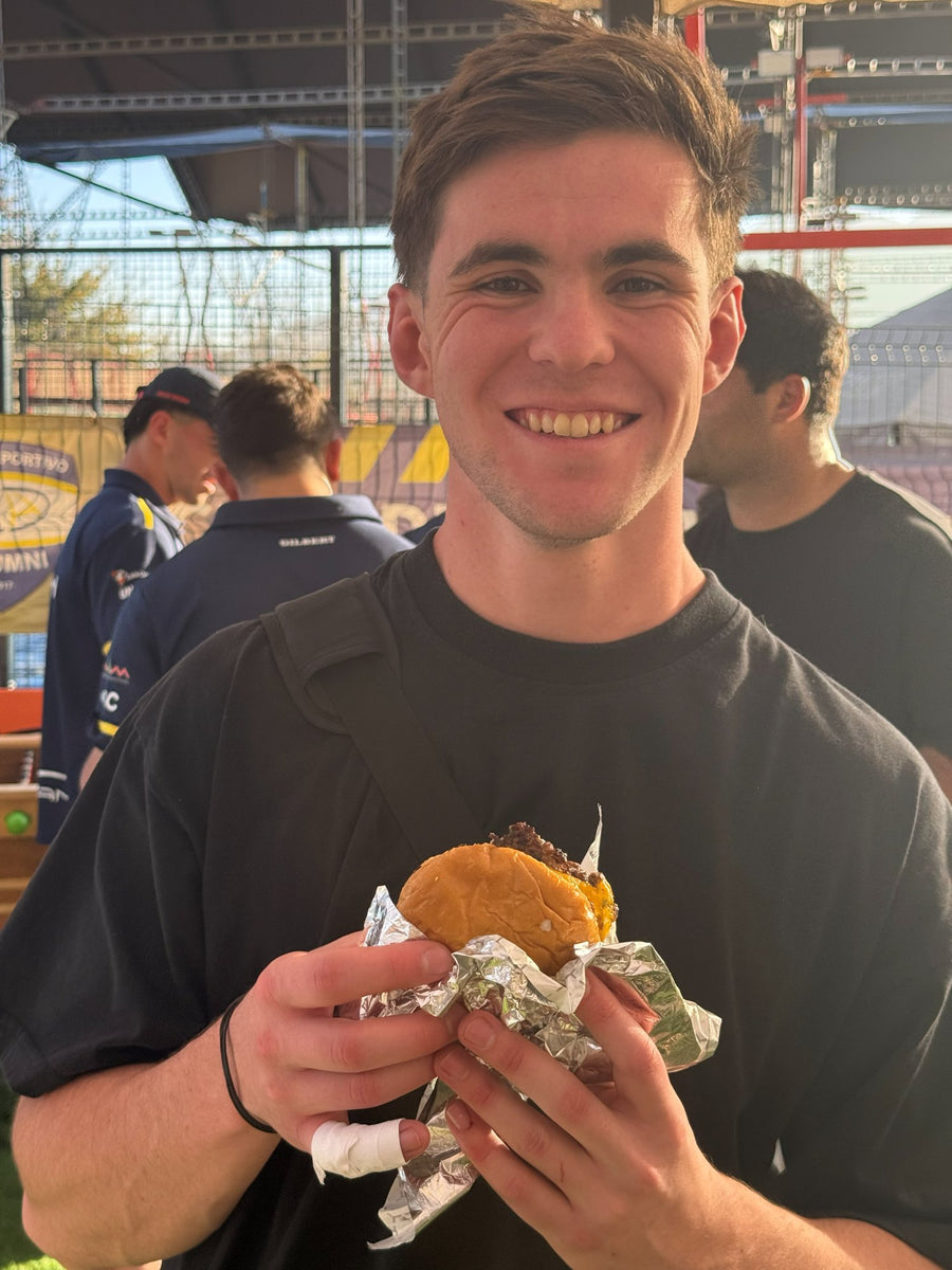 Jugador sonriendo con su smash burger en el tercer tiempo